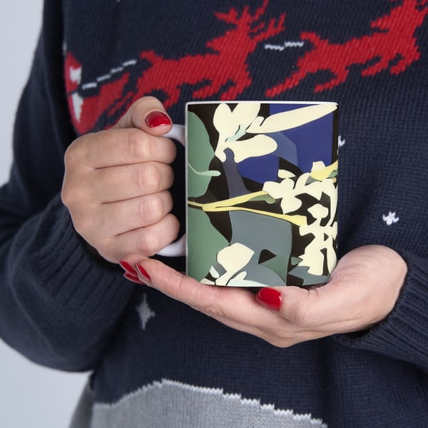Hands holding a mug with a digital artwork of abstract botanical shapes in blue, green, and yellow tones, symbolizing a Montessori-inspired appreciation for nature's aesthetics.